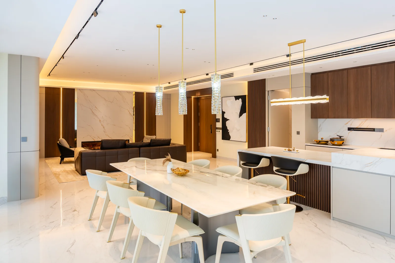Long white dining table beside an open kitchen island with crystal pendant lights, Park Regent, Desa ParkCity, Kuala Lumpur, Malaysia, by Blaine Robert Design