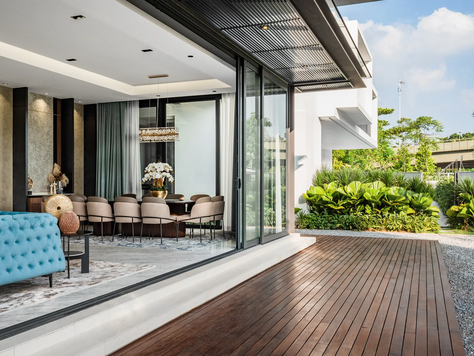 Dining room opening through sliding glass doors to a timber deck and garden, Kelana Jaya bungalow, Selangor, Malaysia, by Blaine Robert Design
