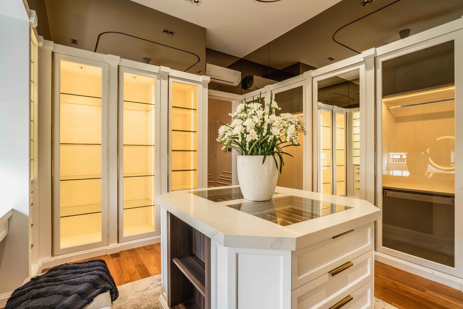 Central island with drawers and lit glass display cabinets inside a walk-in wardrobe, Eco Spring, Johor Bahru, Malaysia, by Blaine Robert Design