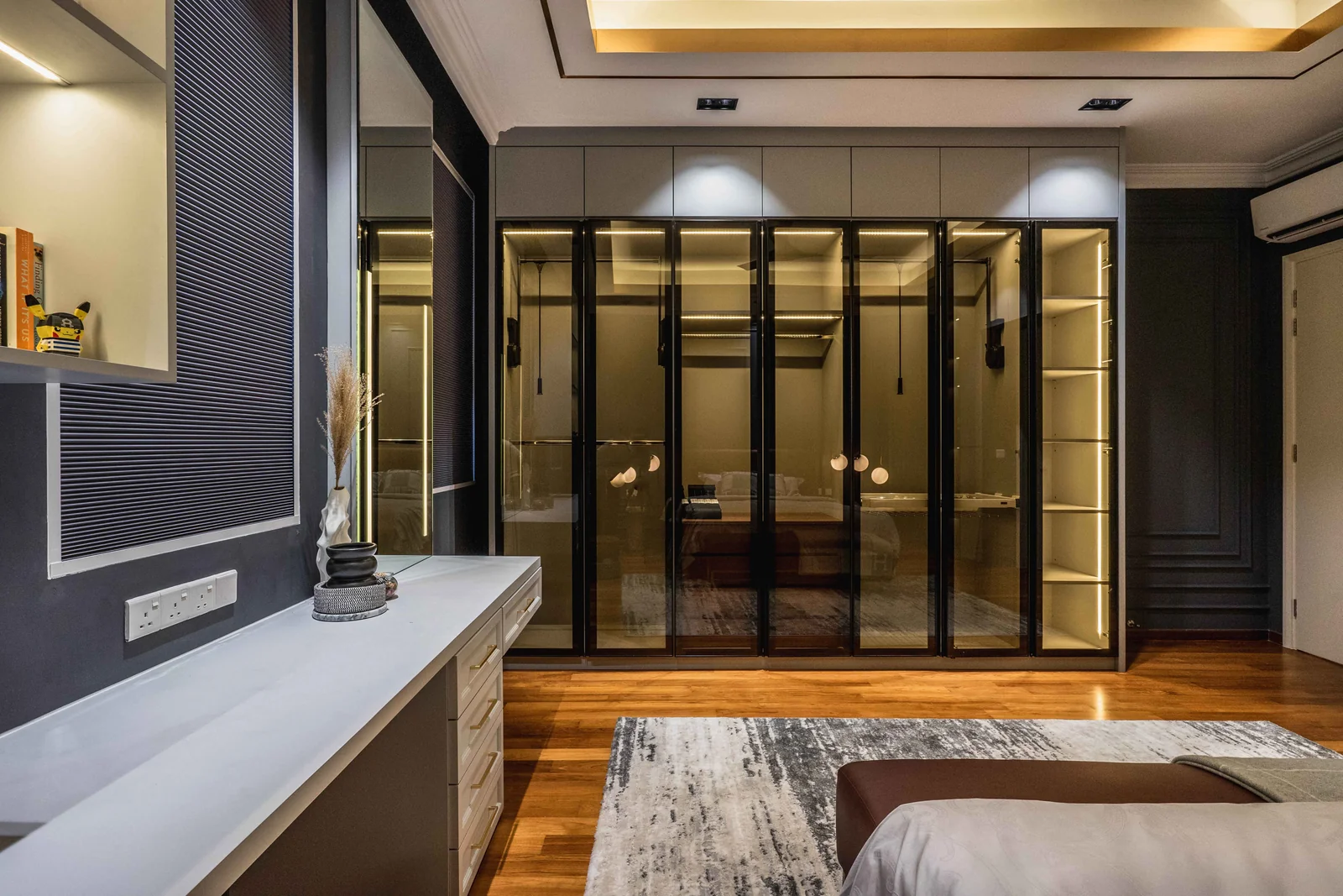 Floor-to-ceiling glass-fronted wardrobe wall with internal lighting in a master bedroom, Eco Spring, Johor Bahru, Malaysia, by Blaine Robert Design