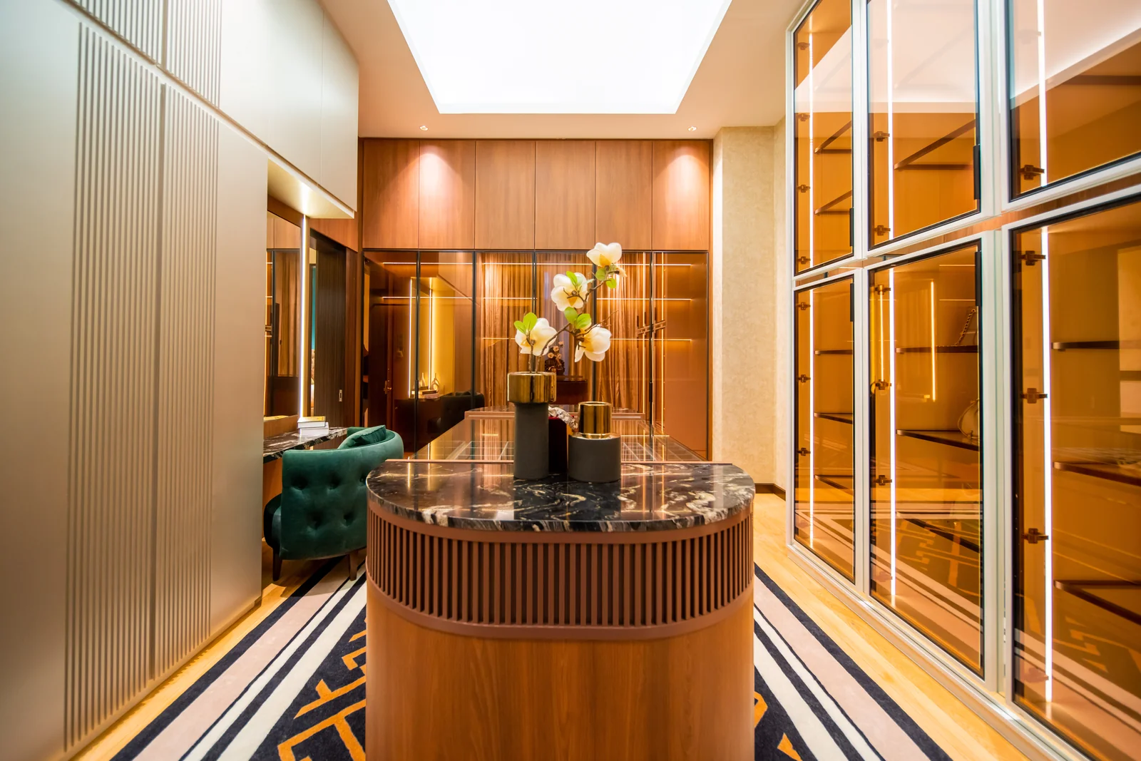 Walk-in closet with a round fluted island, a full-length mirror and glass wardrobes, Bangsar, Kuala Lumpur, Malaysia, by Blaine Robert Design