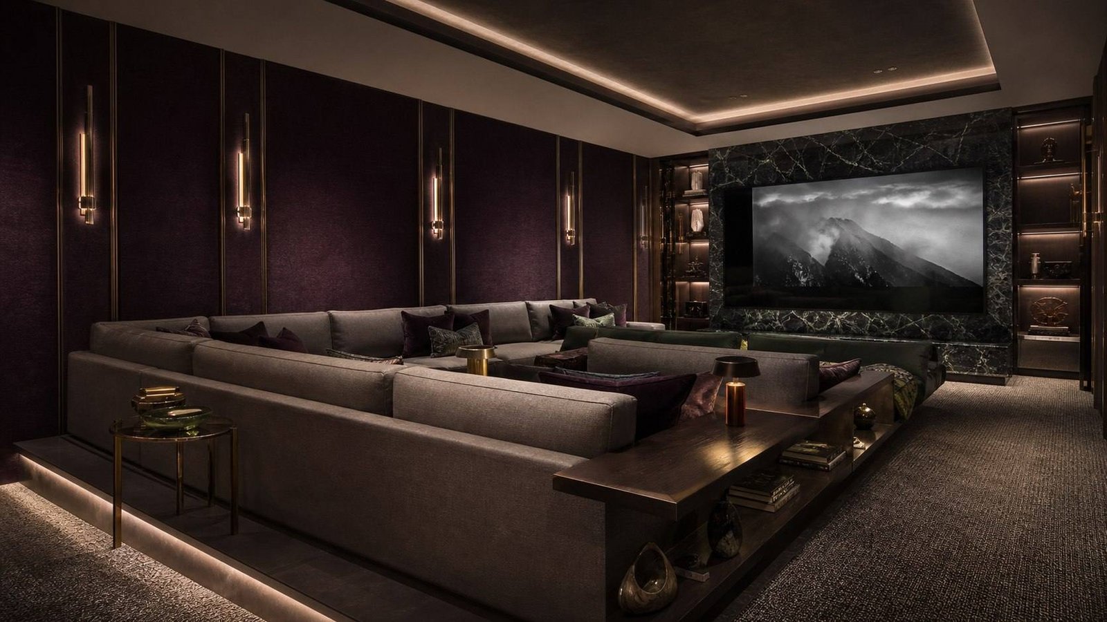 Private cinema with a deep U-shaped sofa, upholstered aubergine wall panels, brass wall lights and a stone media wall, Jewel Box Modernism, Mumbai, by Blaine Robert Design